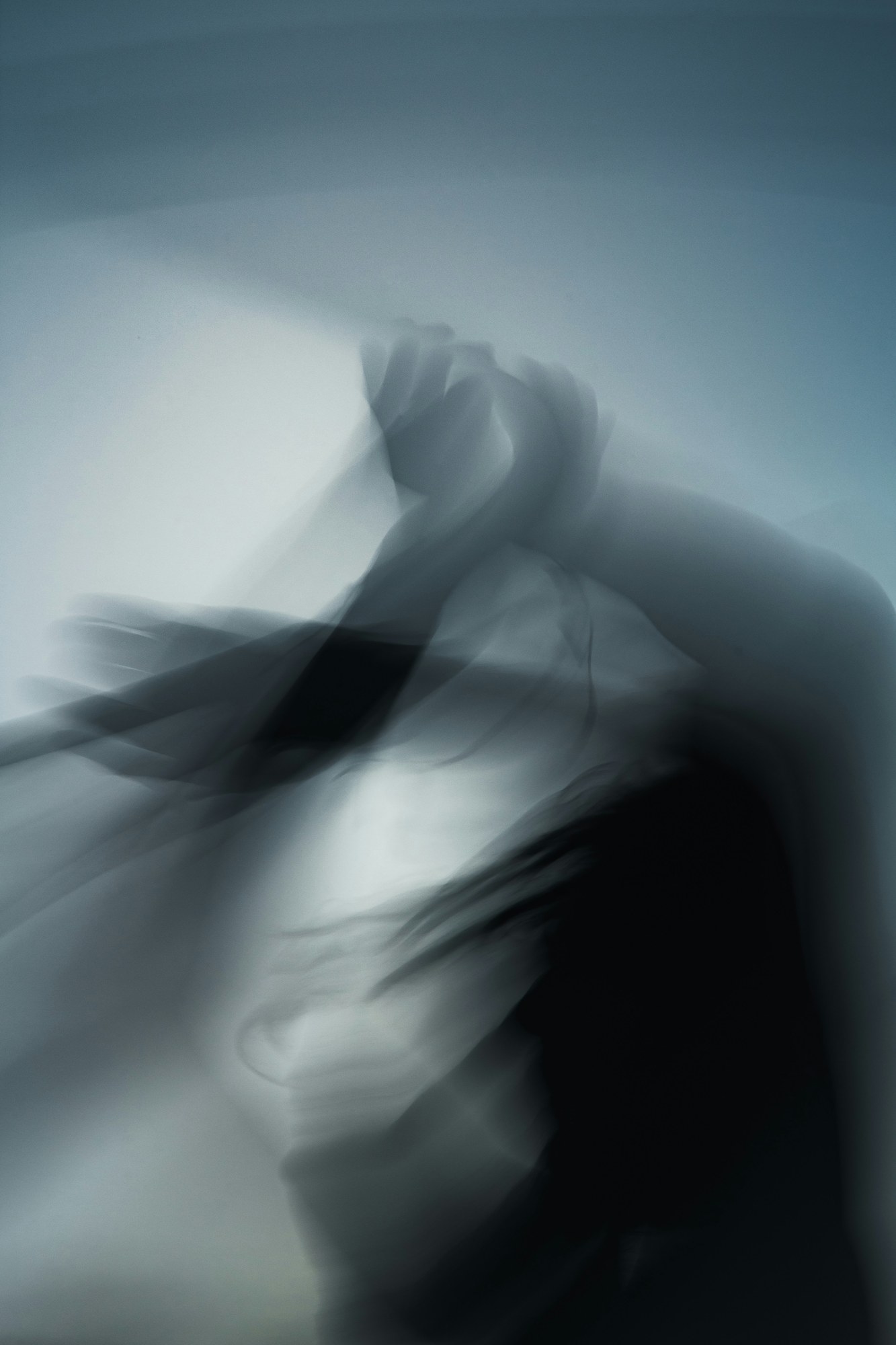 An abstract photograph of a dancer moving with flowing fabric.